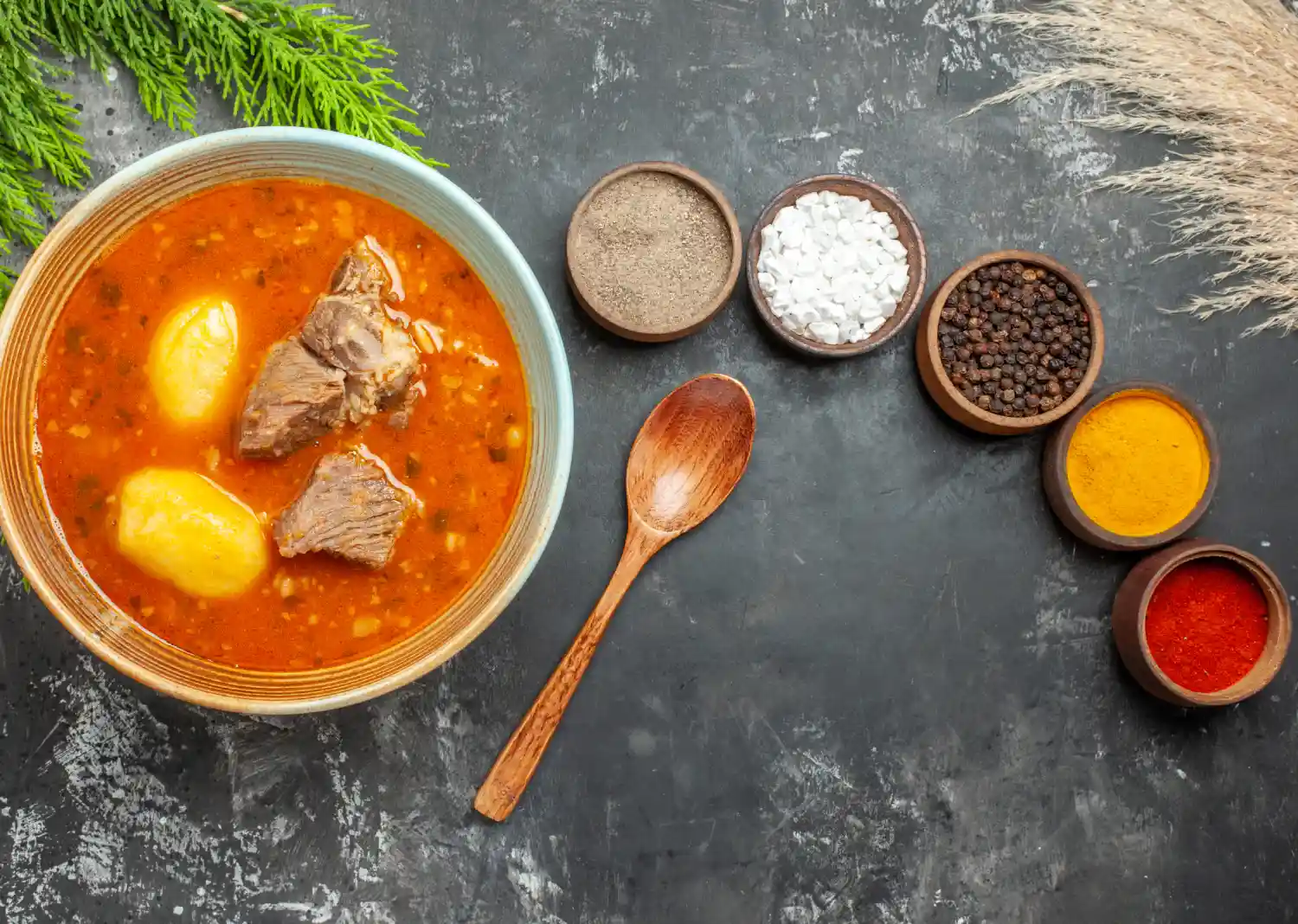 Abgoosht Recipe featuring a bowl of Persian stew with lamb, potatoes, and spices, served alongside seasoning ingredients.