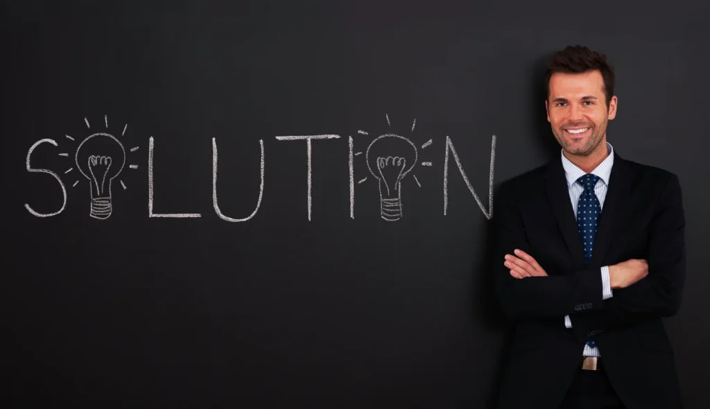 How to identify a business idea: man in suit by "solution" on chalkboard.
