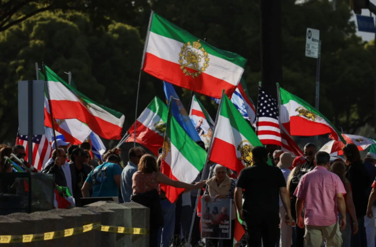 Crowd waving Iranian lion-and-sun flags at a pro-regime-change rally