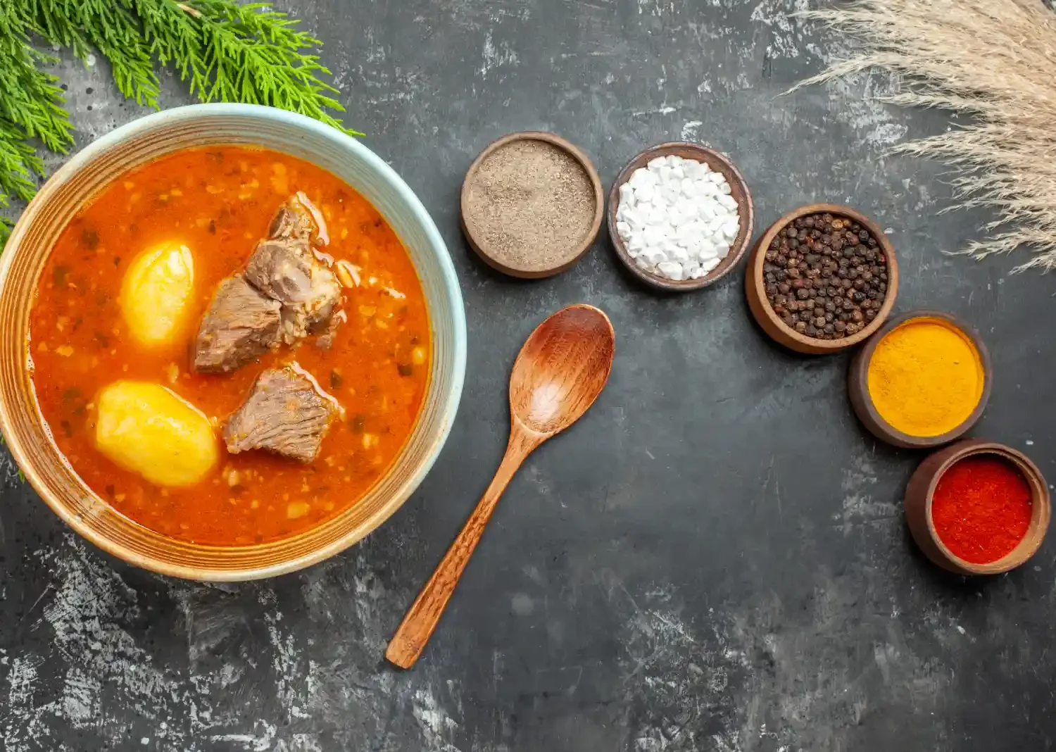 Abgoosht Recipe featuring a bowl of Persian stew with lamb, potatoes, and spices, served alongside seasoning ingredients.