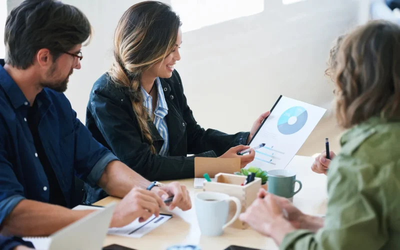 Team of professionals discussing a business growth chart in a meeting.