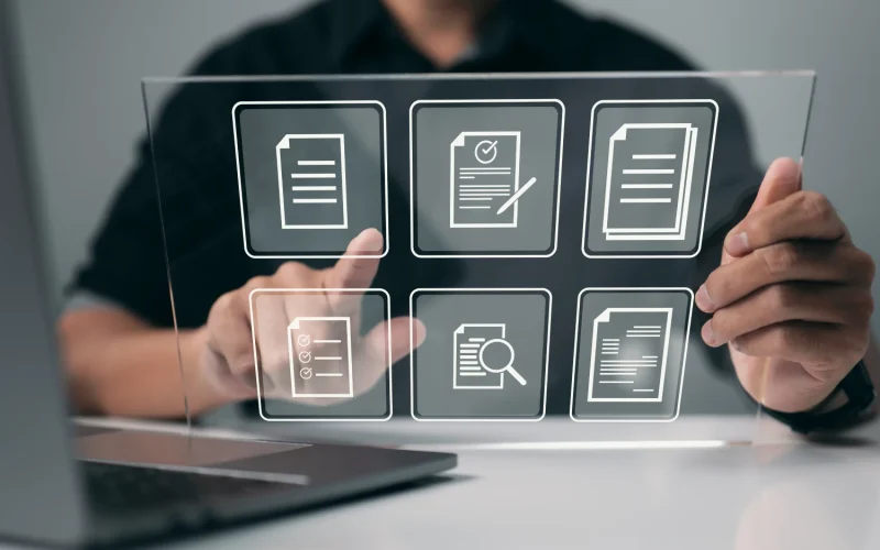 Person selecting digital business tools displayed on a transparent screen.