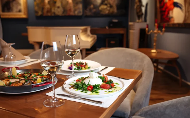 Elegant table setting with beautifully plated Persian-inspired dishes and wine glasses in a fine dining restaurant.
