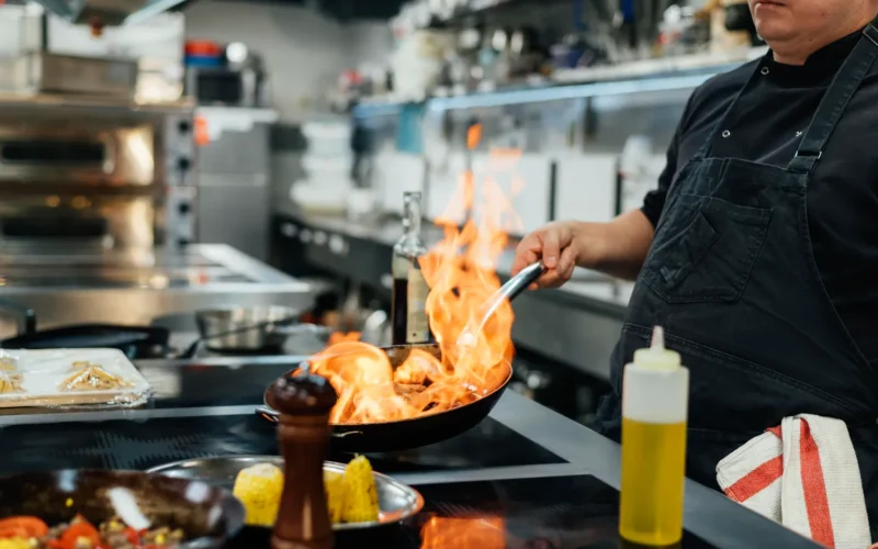 Chef preparing Persian cuisine with flaming pan at an Iranian restaurant in Charlotte.