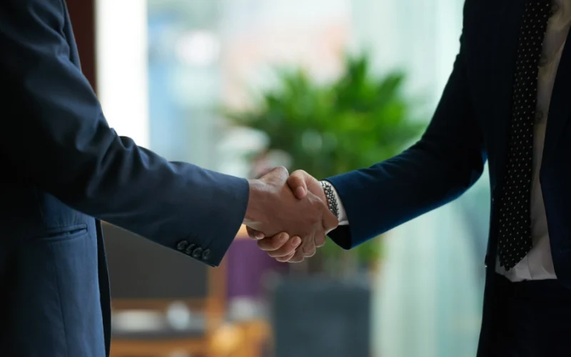 Two business professionals shaking hands, symbolizing partnerships in Iranian businesses in California.